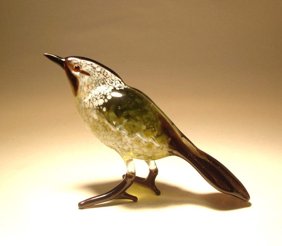 Side view of a glass Black & White Warbler bird figurine, showcasing its intricate black and white feather patterns.