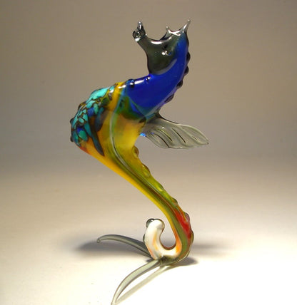 view of the glass blue seahorse figurine, focusing on the craftsmanship of its head, spiraled tail, and fine detailing on the fins.