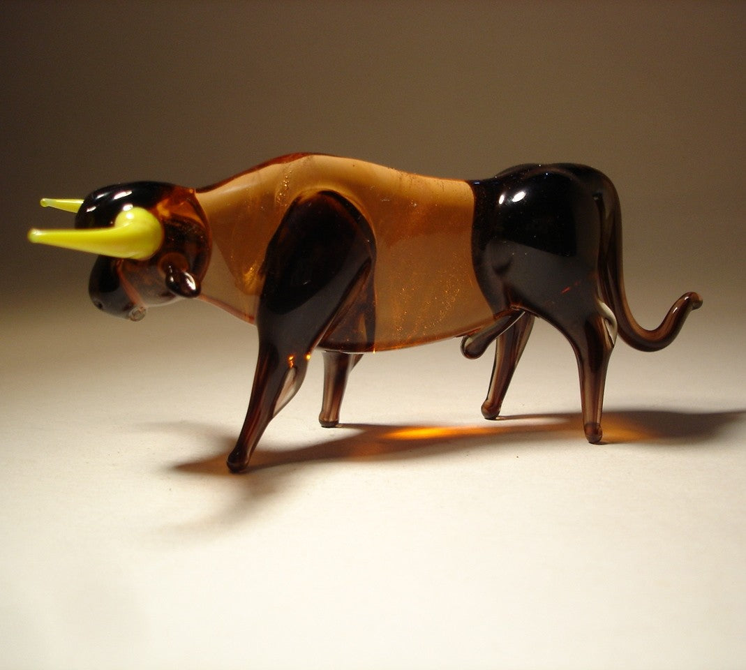 Left side of the brown bull with yellow horns figurine