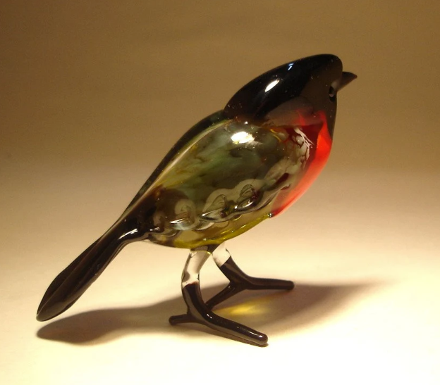 Another side view of the glass bullfinch bird figurine, highlighting its black head, tail and intricate wings.