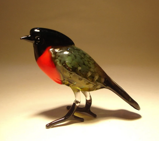 Side view of a glass bullfinch bird figurine, showcasing its vibrant red chest and dark grey glossy back.