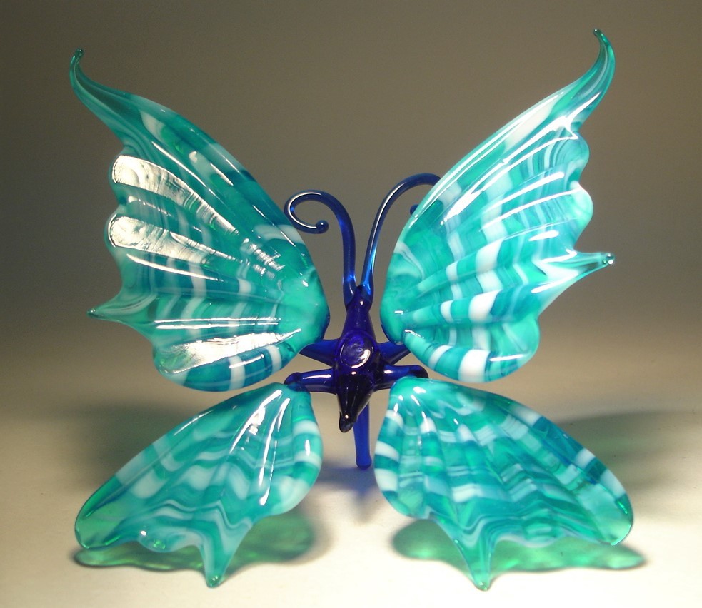 A front view of the white and blue striped glass butterfly figurine, showcasing its graceful shape and the artistic design of its wings.