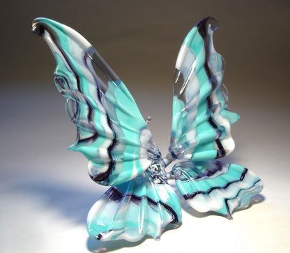  display view of a white and blue striped glass butterfly figurine positioned on a surface.