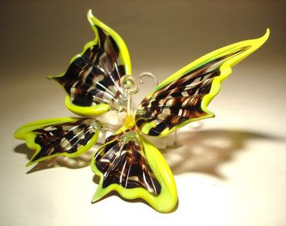 Side view of the yellow and black glass butterfly, highlighting its open wings and elegant shape.