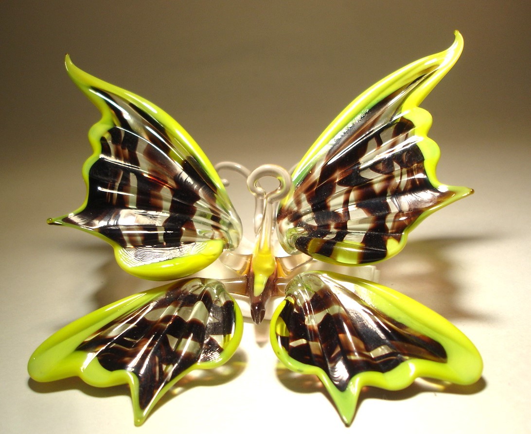 Close-up of a yellow and black glass butterfly ornament, featuring a striped wing pattern.