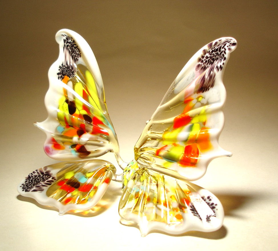 A vibrant white and red glass butterfly figurine, featuring intricate wing patterns.