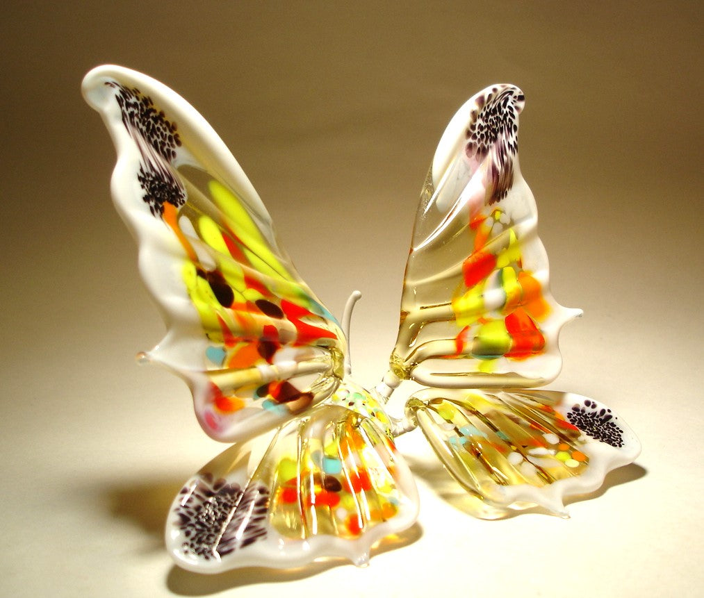 A side angle of the white and red glass butterfly figurine, emphasizing the elegant curves of its extended outward wings.