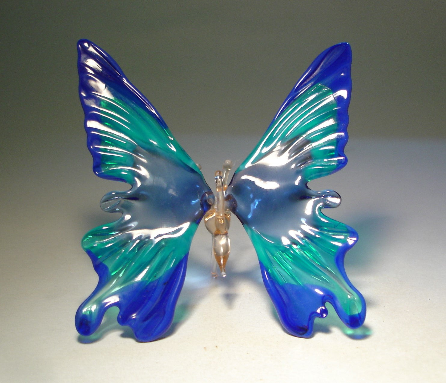 Front view of a handcrafted blue glass hanging butterfly ornament, showcasing its vibrant blue wings and intricate detailing