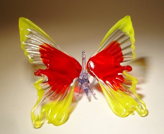 Front view of a yellow and red glass butterfly ornament, featuring a glass hanging loop.