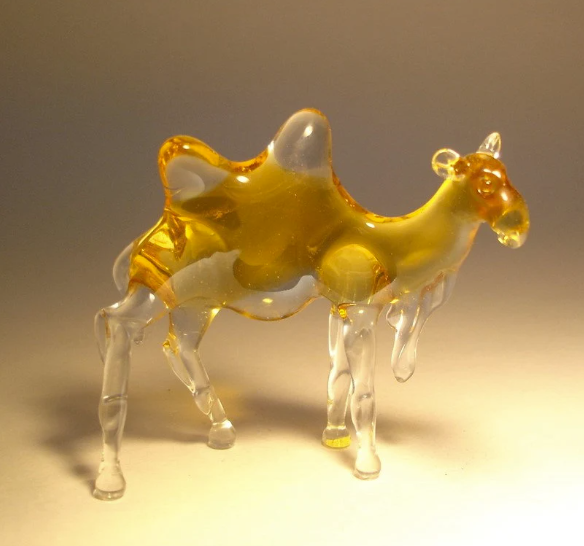 Front view of a glass camel figurine, showcasing its distinct two humps, long clear glass legs, and light brown body.