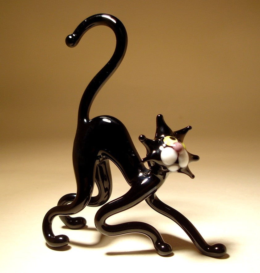 Side view of a handmade black glass cat figurine with a curved back, showcasing the sleek, smooth design and poised stance