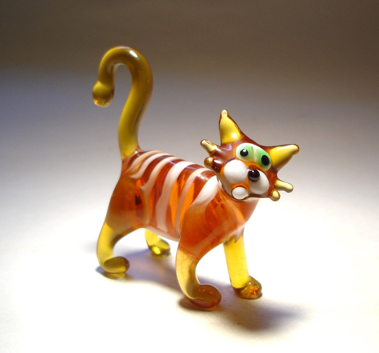 Glass brown cat figurine with white stripes,  green eyes and curved tail