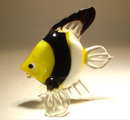 Left side view of a glass clown fish figurine, displaying its bright yellow, black and white stripes.