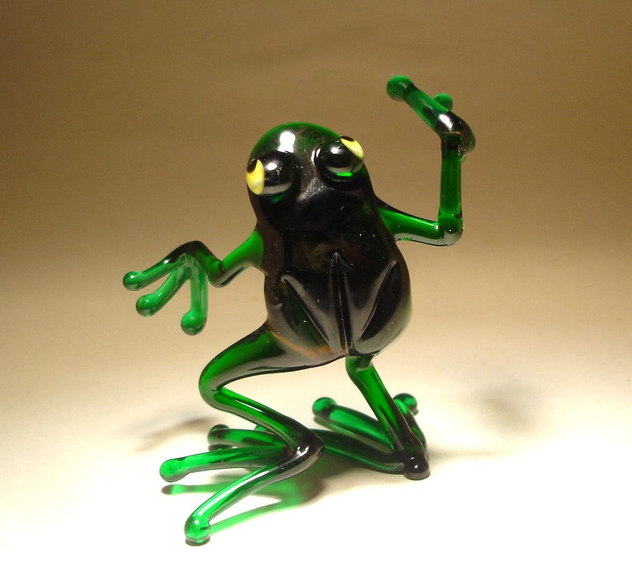 Close-up of the glass dancing frog figurine, focusing on the frog's joyful expression and dynamic dance pose.