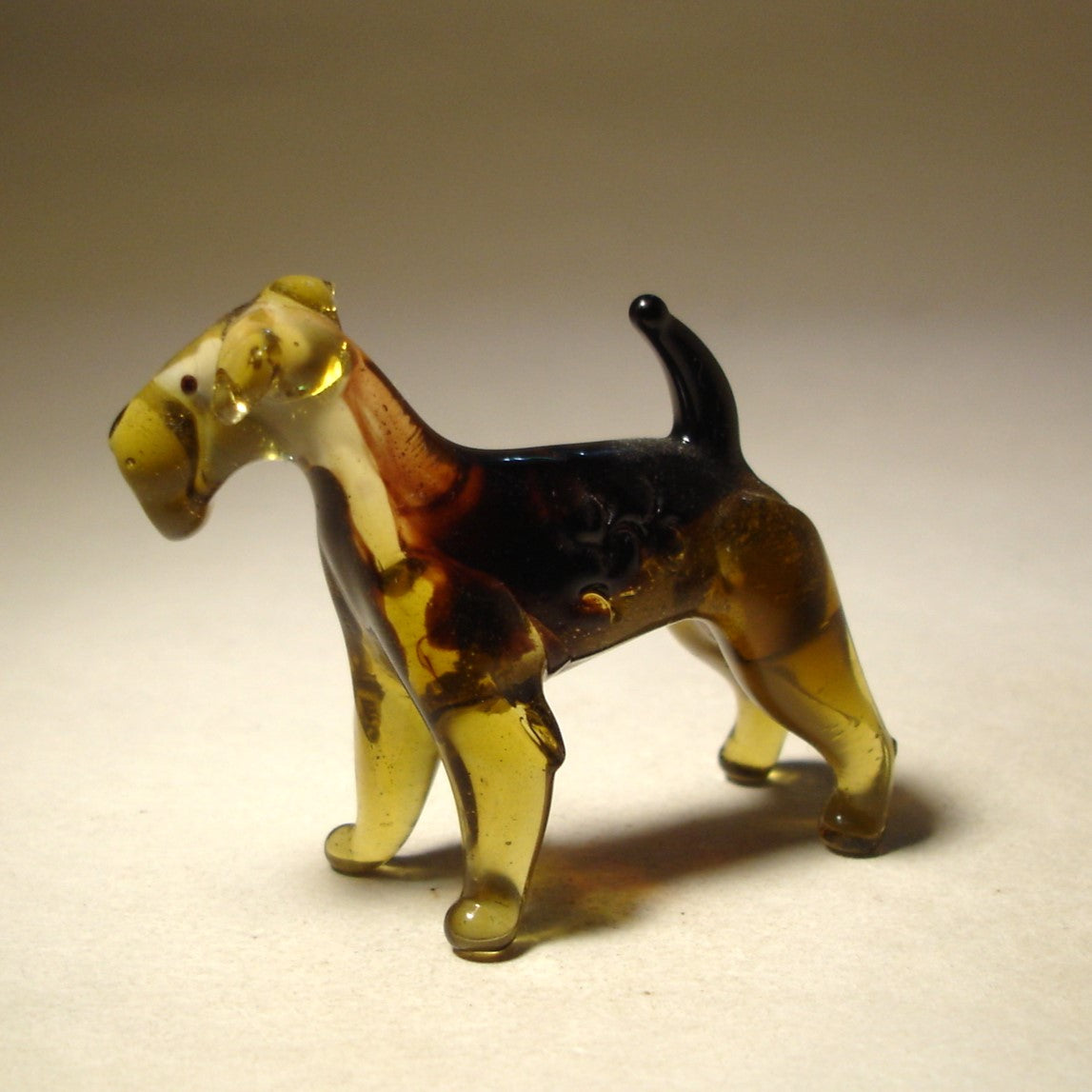 Side view of the glass Airedale Terrier figurine, emphasizing the sculpted features and distinctively textured fur