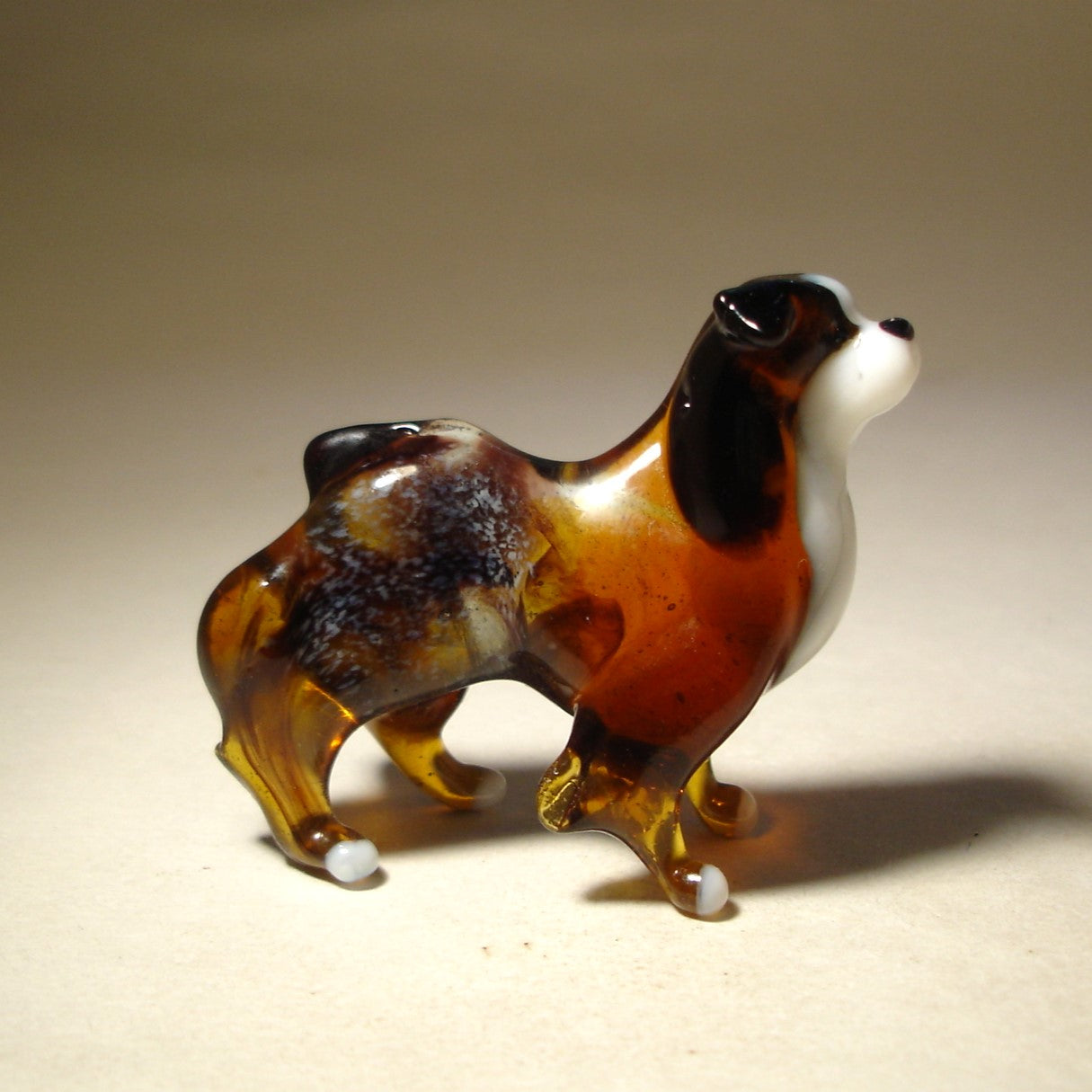 Side view of the glass Border Collie figurine, highlighting its agile body and bushy fur.