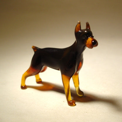 Close-up of the glass Doberman figurine’s head, highlighting its alert expression and pointed sharp ears.