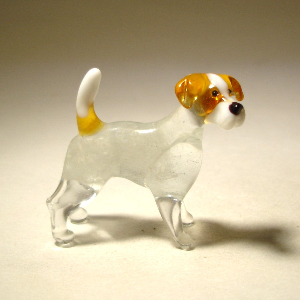 A handmade glass figurine of a Jack Russell Terrier, showcasing its small size and athletic build, with distinct  brown markings.