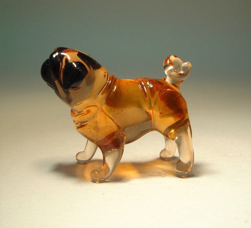 Side view of the glass Pug figurine with black markings on its face.