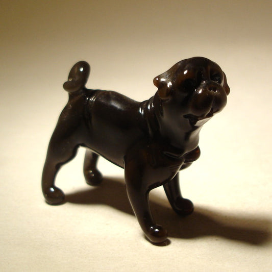 Handcrafted glass Black Pug figurine sitting with a joyful expression, showcasing its rounded body and distinctive facial features.