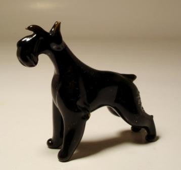 A charming glass Schnauzer figurine stands proudly, showcasing its distinctive beard and bushy eyebrows. 