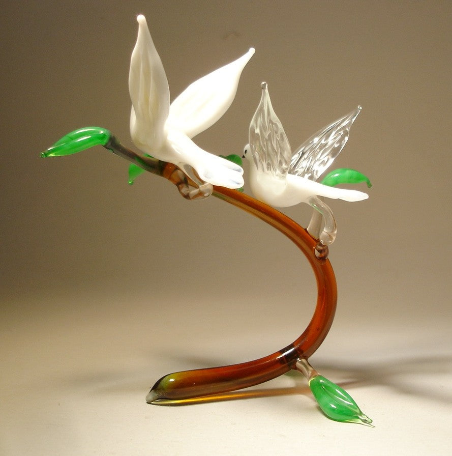 view of the glass white doves on a branch figurine, emphasizing the symmetrical arrangement of the white doves.