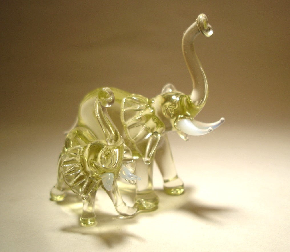 A close-up of the glass elephant and baby duo showcases their detailed trunks lifted up.