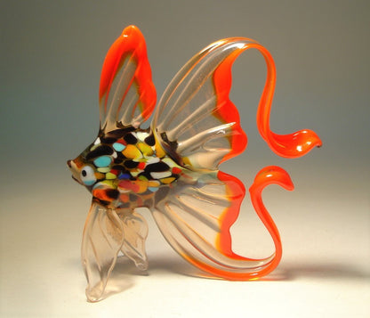 A side view of the red and clear exotic glass fish figurine, highlighting its arched tail.