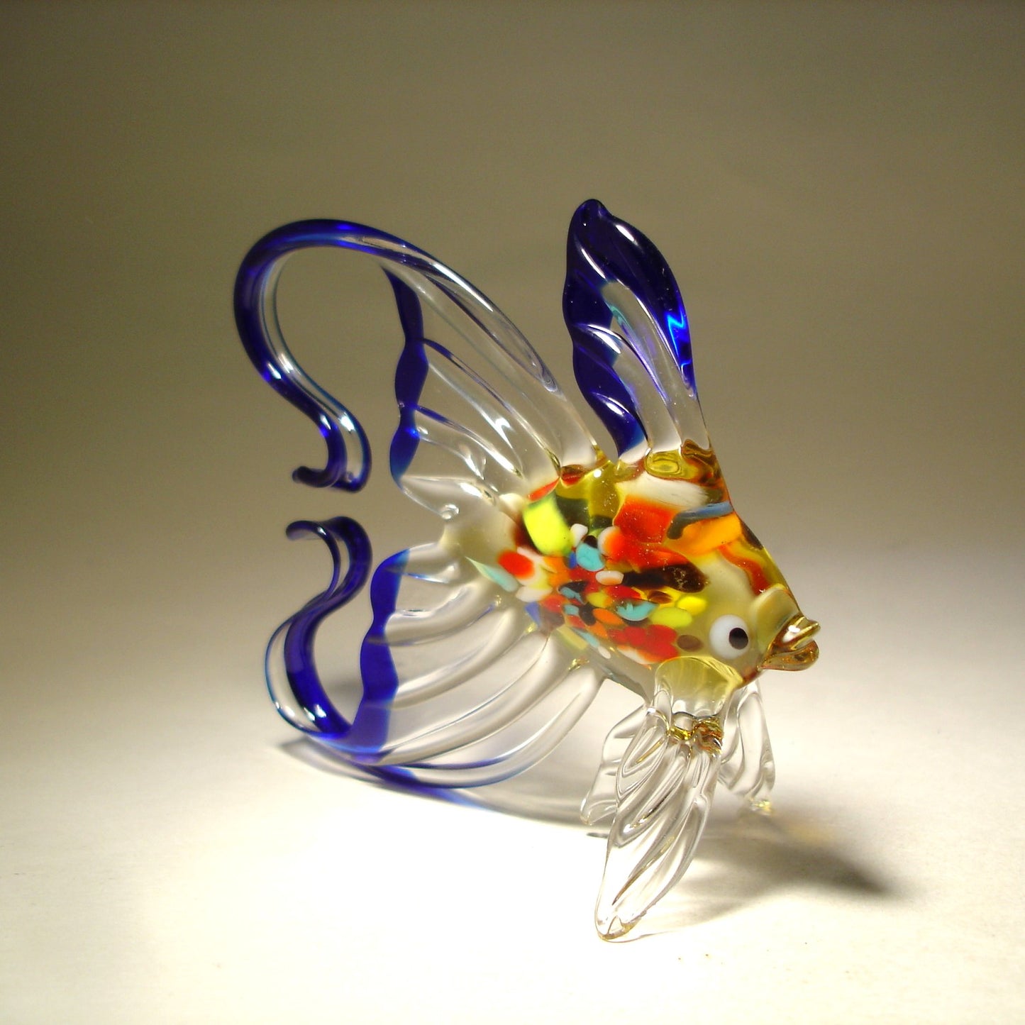 a handmade blue and clear exotic glass fish figurine with colorful body