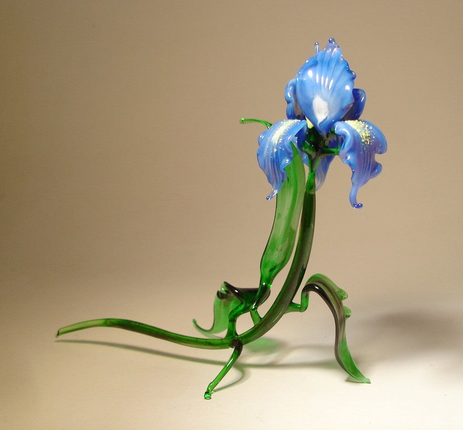 Side view of the glass blue iris figurine, highlighting the intricate curves of the petals and the natural flow of the leaves.