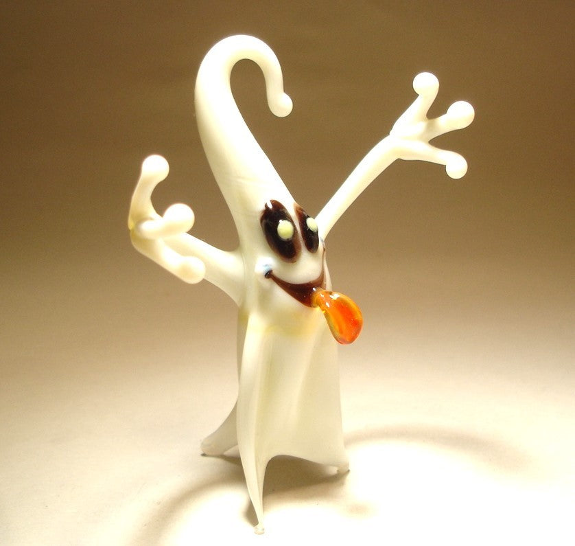 A glass white ghost figurine with its arms raised displaying its friendly and cheerful demeanor.