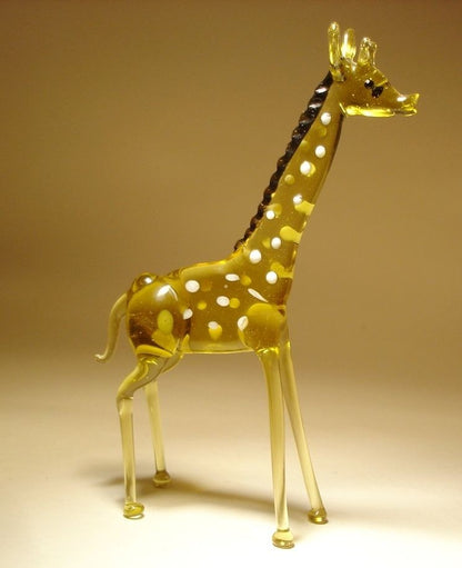 A side view of a glass standing giraffe figurine, showcasing its long neck, detailed facial features, and patterned body.