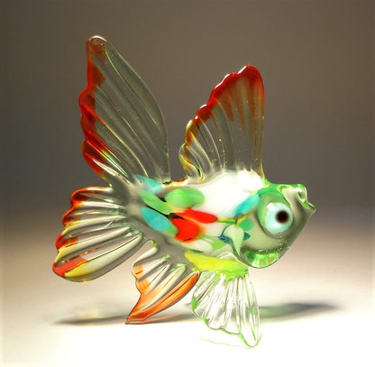 A side profile of the green and red exotic glass fish figurine, showcasing its elegant fins and arched body. 