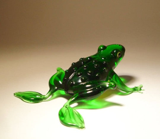 A back view of the glass handmade frog figurine; sculpted back with small round bumps characteristic for frogs.
