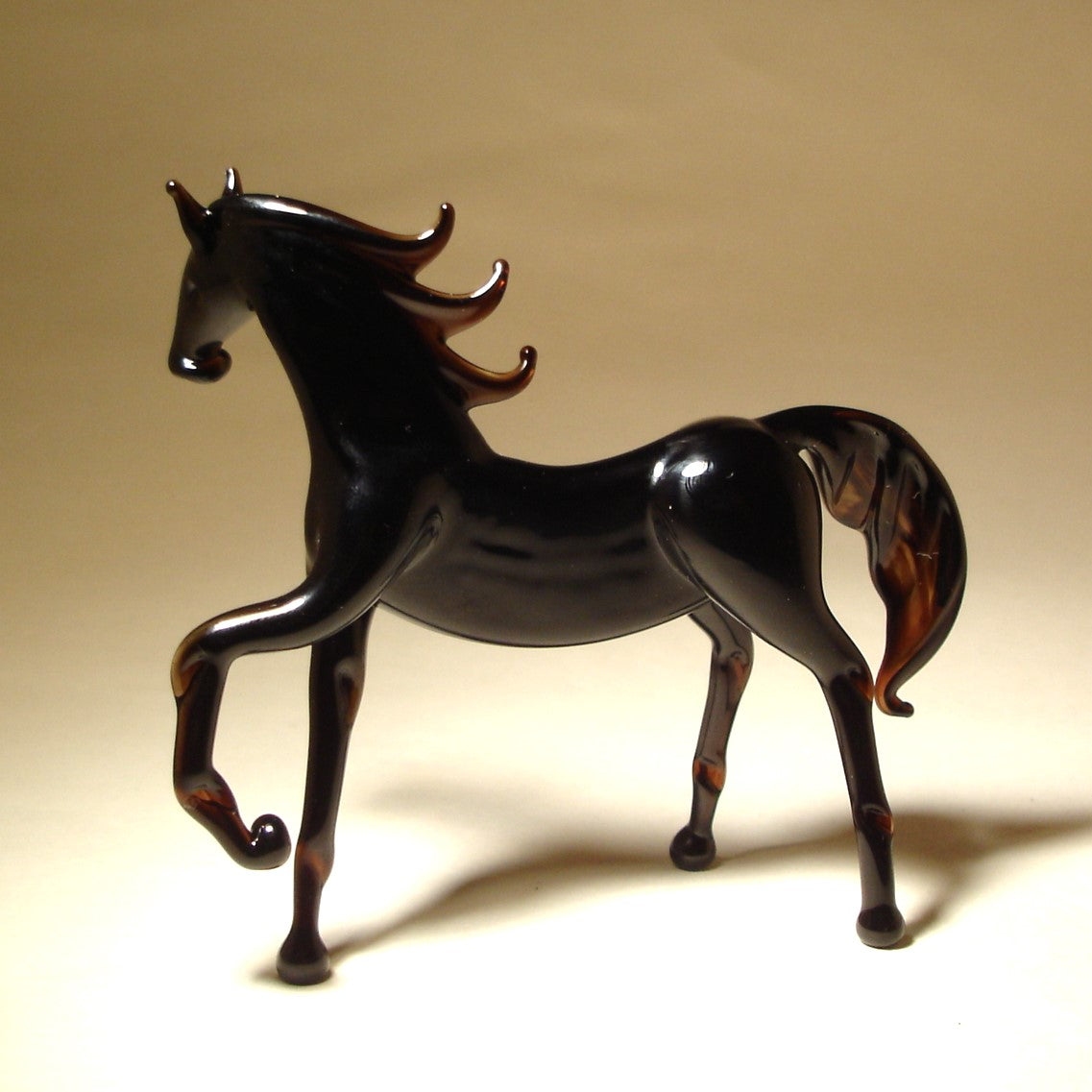 Angled view of the Glass Black Horse Figurine, emphasizing the dynamic posture and the intricate craftsmanship of its flowing mane and tail