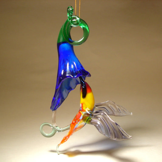 Glass red and yellow hummingbird figurine hovering next to a vibrant blue flower ornament