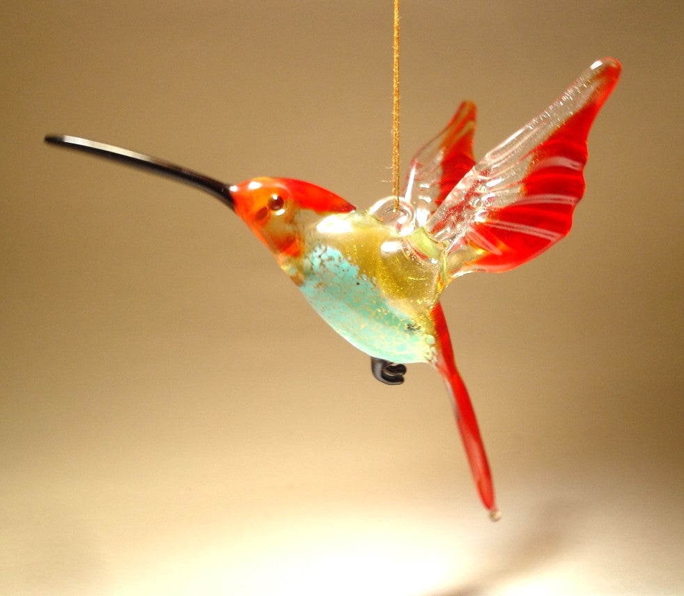 Handmade glass hanging hummingbird with red and clear wings and tail and blue belly.