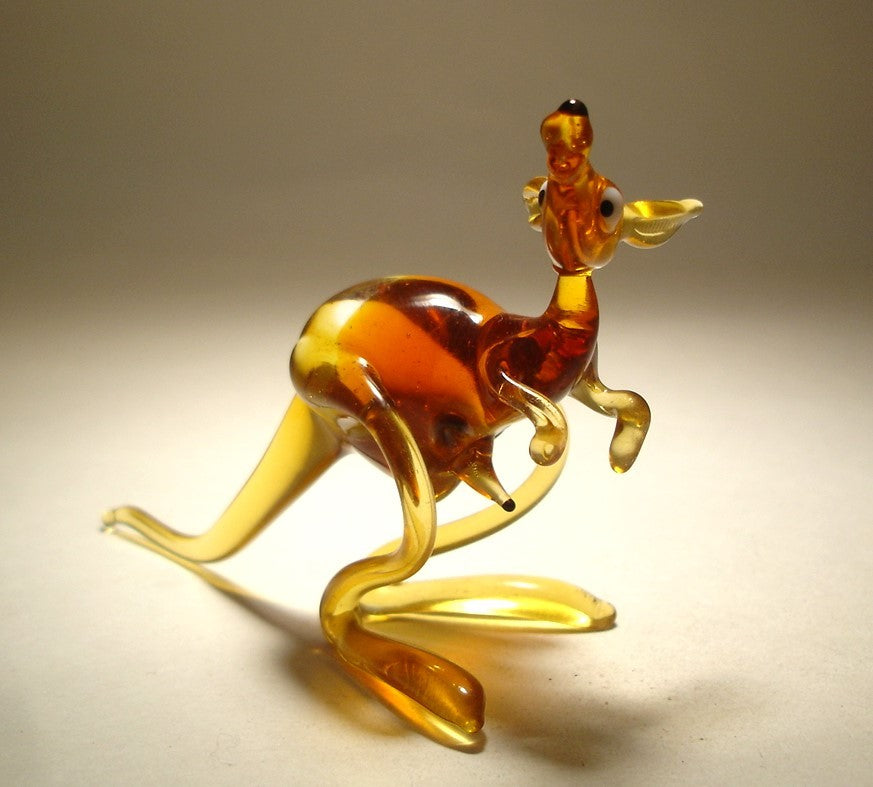 A beautifully crafted glass figurine of a kangaroo with a baby joey in her pouch, standing upright with lifelike posture.