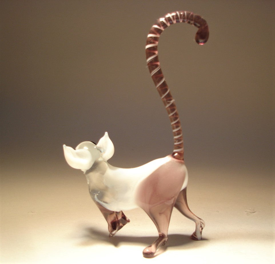 a backside view of the glass monkey lemur showcasing its long magnificent tail in lilac with white stripes. 