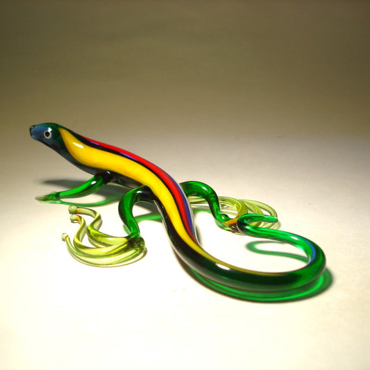 green glass lizard figurine with yellow and red stripes along its back