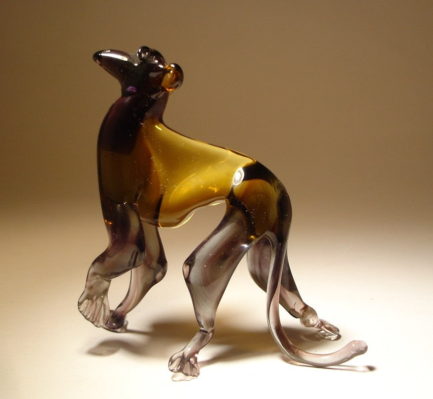 Side view of the brown and grey glass monkey figurine with its left paw raised.