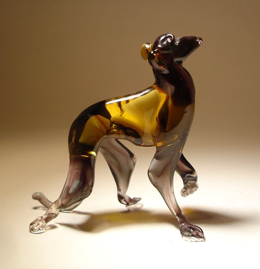 Glass monkey figurine standing with one paw raised in a playful pose.