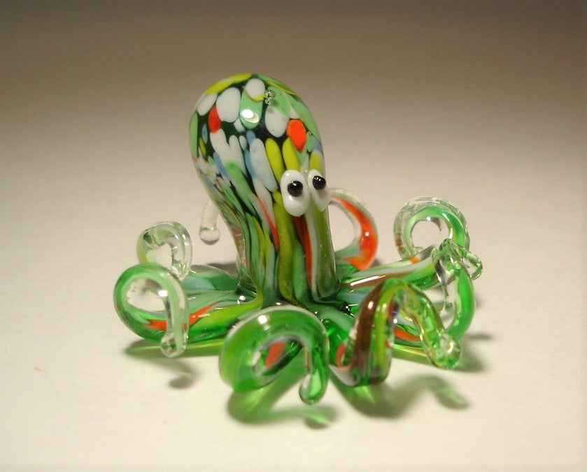 A glass figurine of an octopus in vibrant green, displaying its rounded head and eight gracefully curled tentacles.