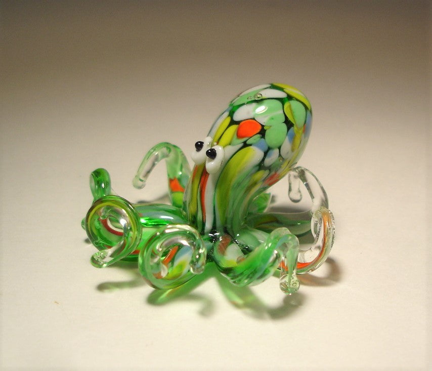 A side profile of the green glass octopus figurine, showcasing the elegant curves of its tentacles as they extend outward. 