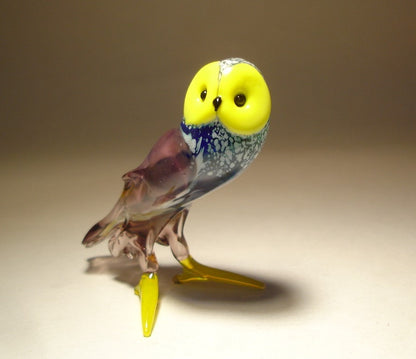 Front view of a standing glass owl figurine with expressive yellow face and black eyes.