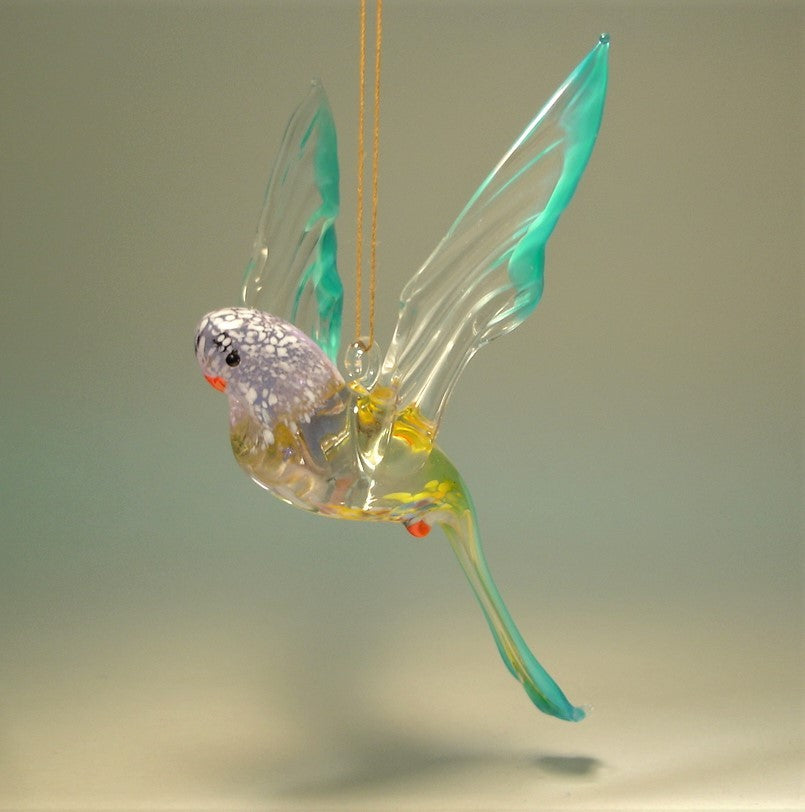 Glass Blue and Yellow Parakeet with a red beak and feet.