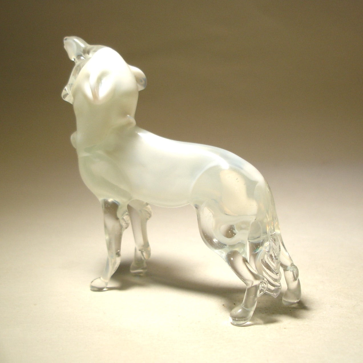 White glass polar wolf figurine, with its leg, tail and face made in clear glass.