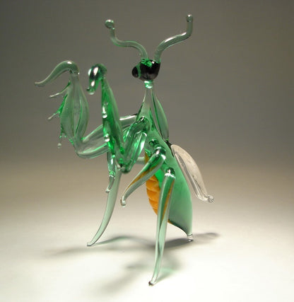 Close-up of the glass praying mantis figurine, highlighting its curved antennae, and finely crafted limbs.