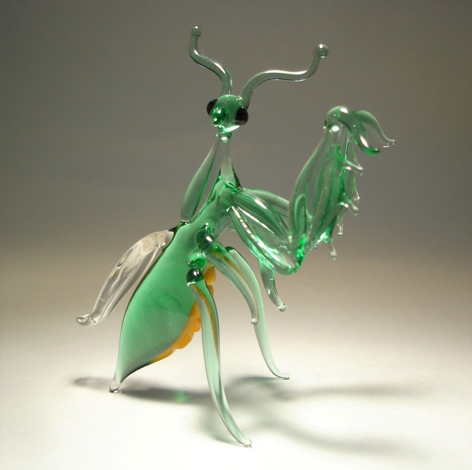 A detailed green glass praying mantis figurine standing upright with front legs raised in a striking pose.