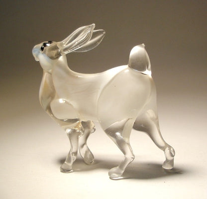 Side view of the glass bunny rabbit figurine, highlighting its fluffy tail and detailed body posture on all four legs.